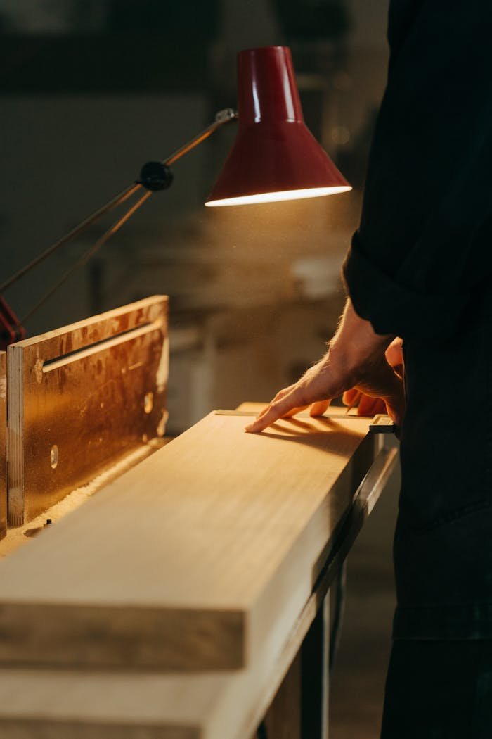 About A skilled craftsman handcrafting wood under warm light in a workshop, focusing on precision.